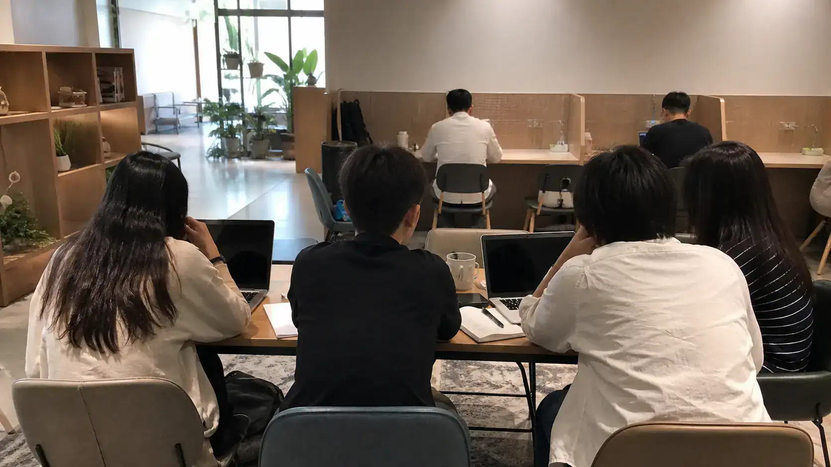四人在台南共同工作空間進行小型交流，後方使用者仍能安靜工作