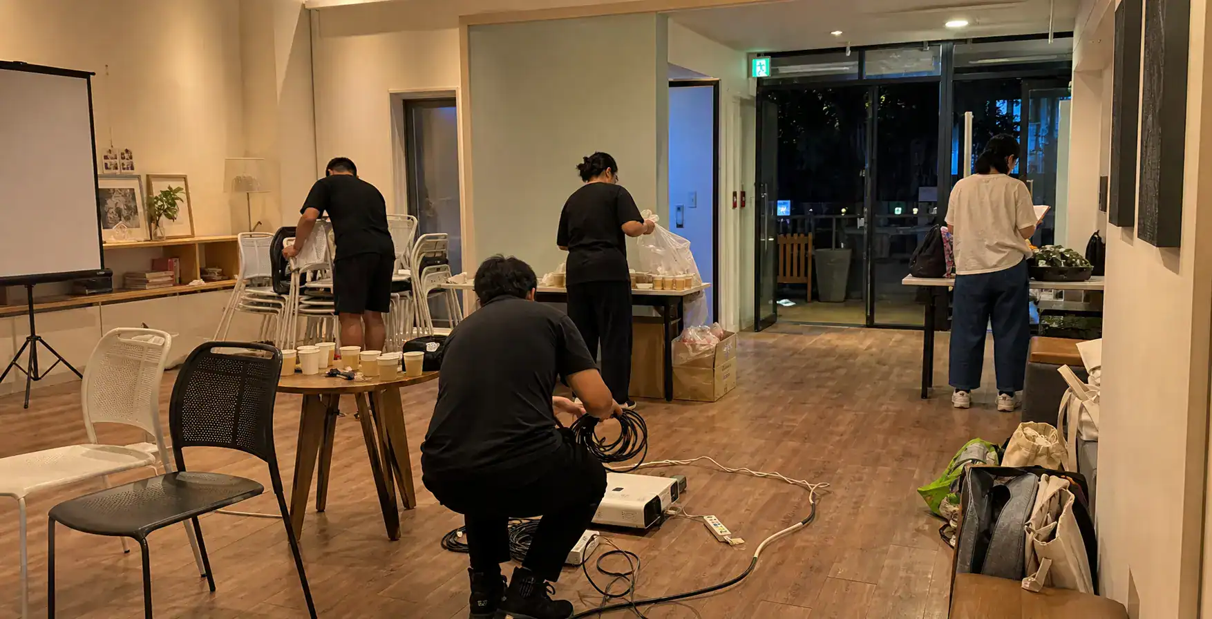 台南包場活動結束後工作人員堆疊座椅、整理線材並分類垃圾
